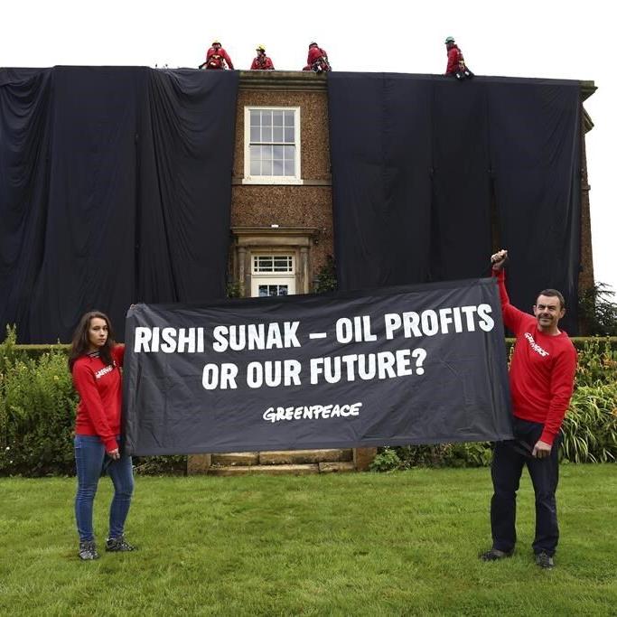 Greenpeace demonstrators drape UK prime minister's house in black to protest oil expansion